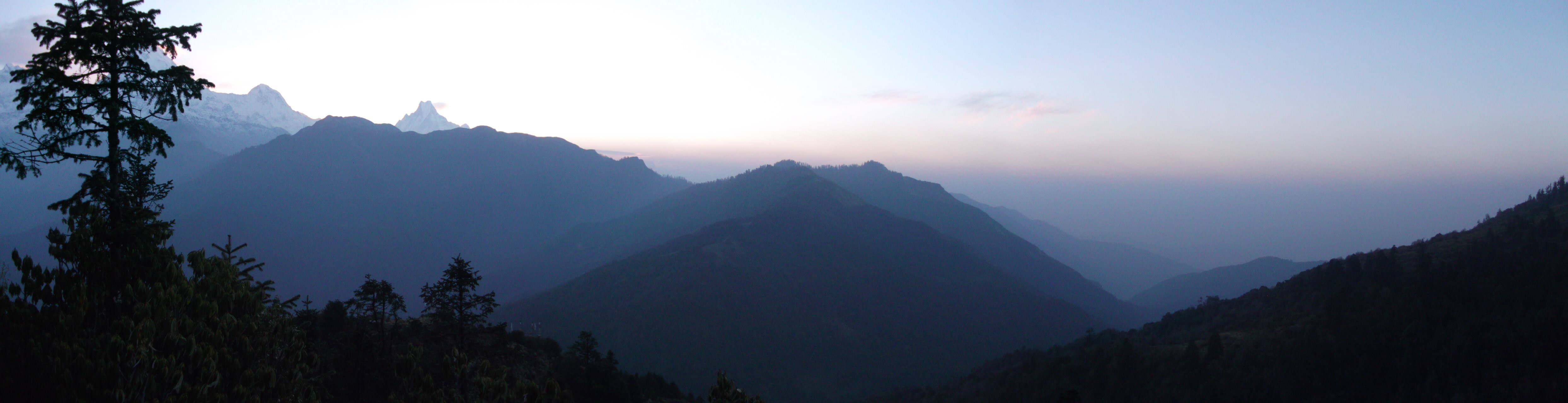 Landscape view of mountains from Poon Hill, Nepal. Sun just rising above mountains.