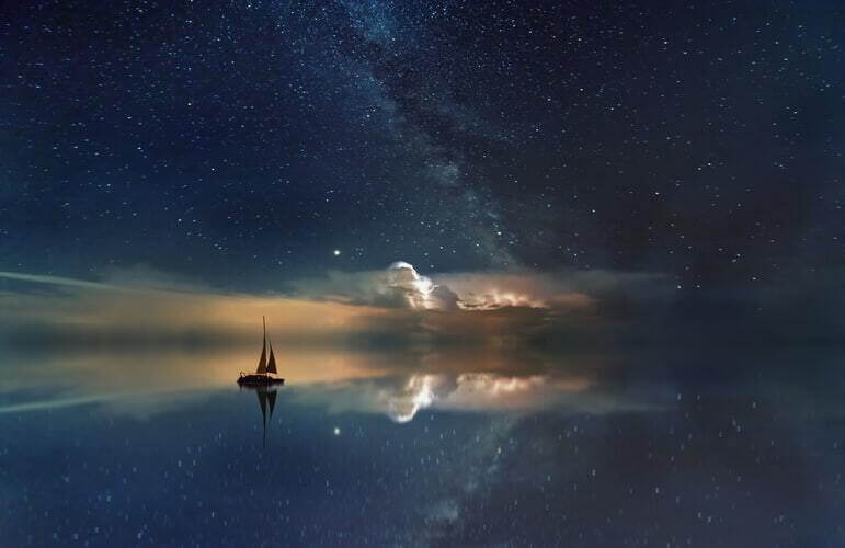 A boat sailing on a becalmed sea at night, smooth as glass.