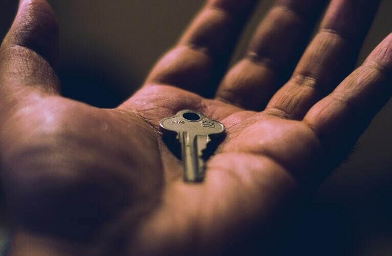 A key lies in the palm of someone's hand.