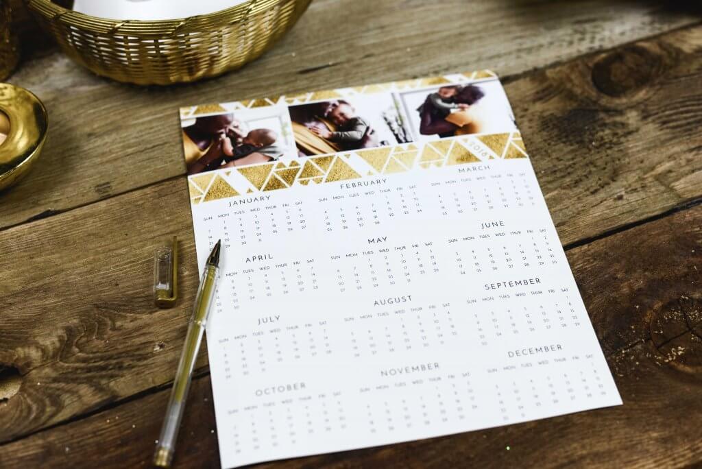 A calendar with a gold pen lying poised next to April.