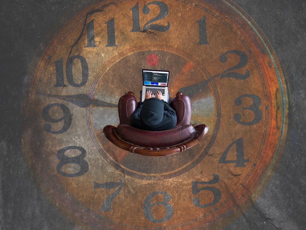 Someone sitting in an armchair working on a laptop, trapped in a massive clock they cannot help but watch.
